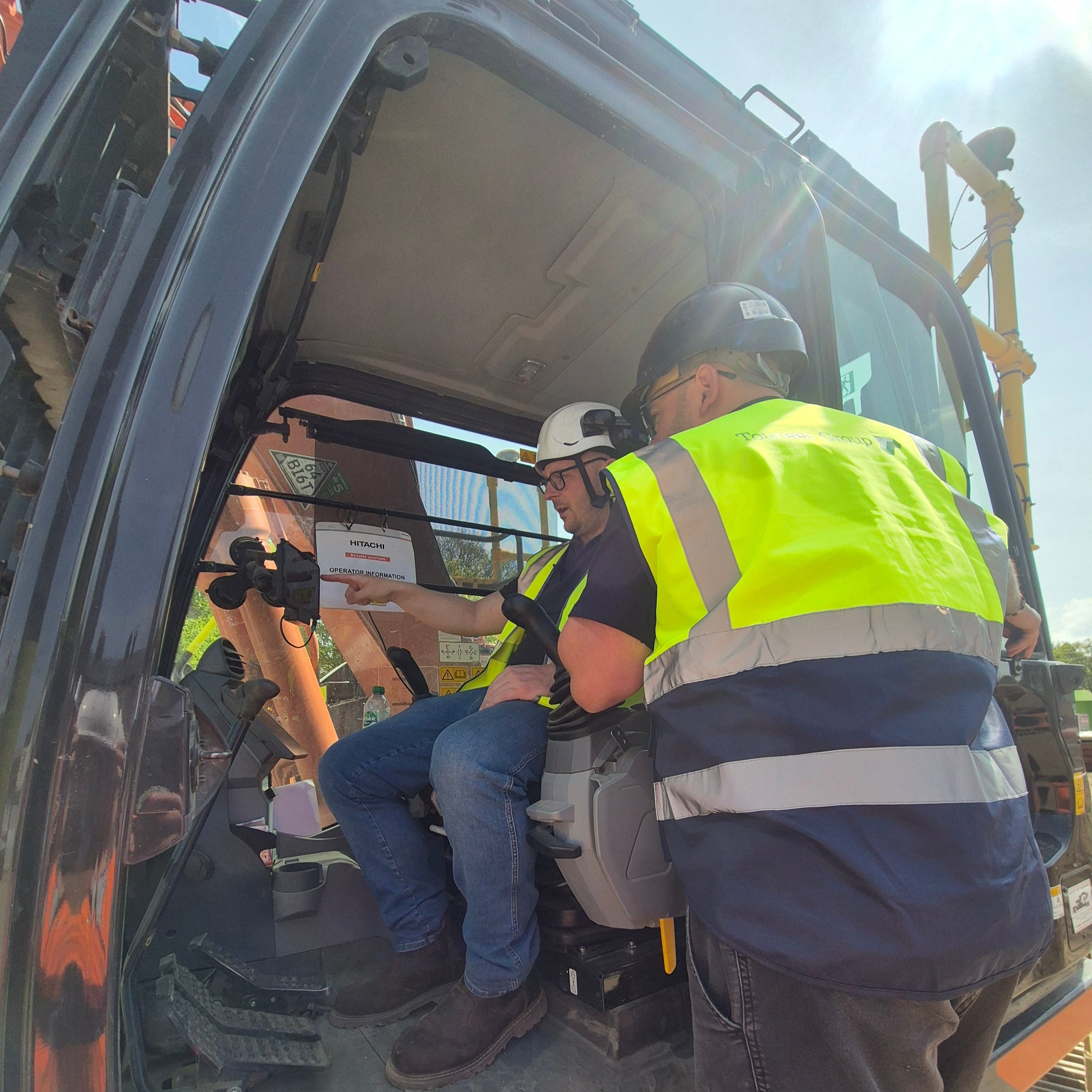 Man in an excavator providing training